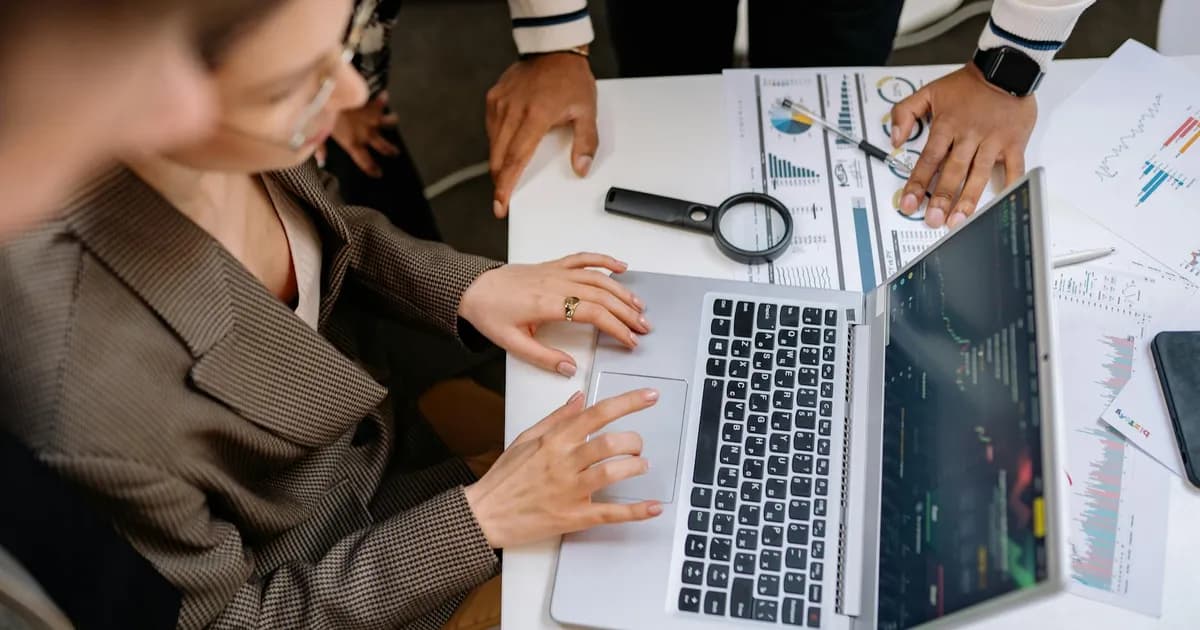 Professionnels analysant des données publicitaires sur un ordinateur portable en réunion de travail