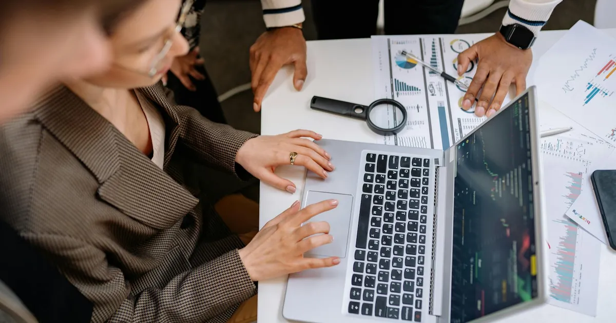 Professionnels analysant des données publicitaires sur un ordinateur portable en réunion de travail