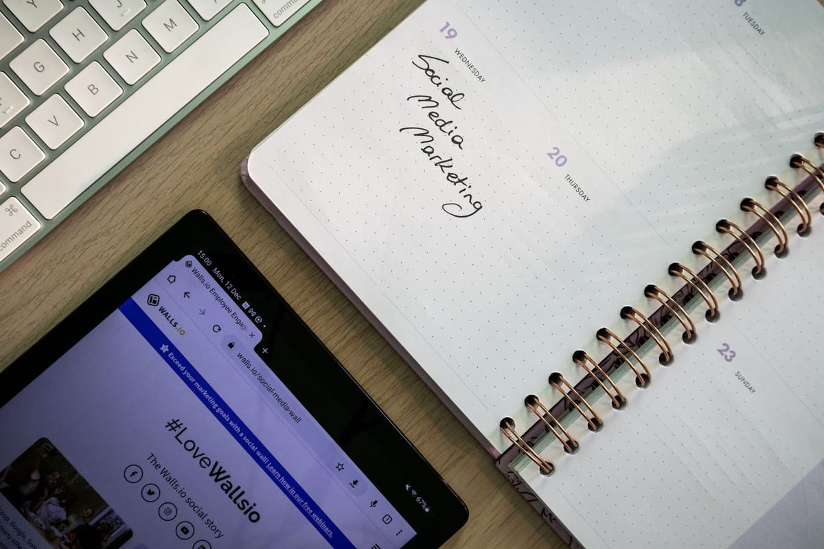 carnet de planification, tablette et clavier vus de dessus sur un bureau de travail
